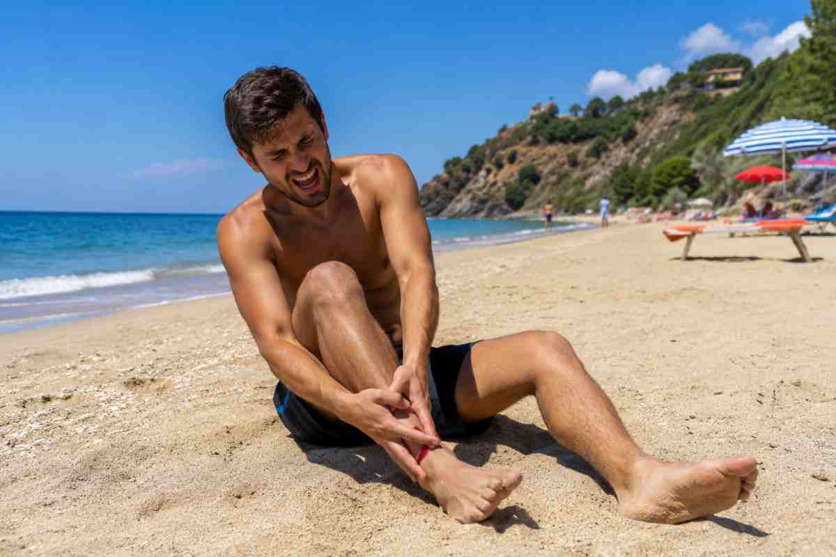uomo in spiaggia infortunato